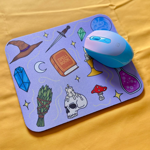 Mouse on a decorative mouse pad with witch themed illustrations.