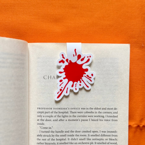 Open book with a red blood splatter magnetic bookmark.