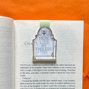 Open book with a tombstone bookmark on an orange background