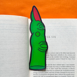 Witch finger shaped bookmark on an open book with an orange background