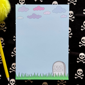 Notepad with a cartoon grave design that says "Dead Inside" on a black background with skull and crossbones pattern