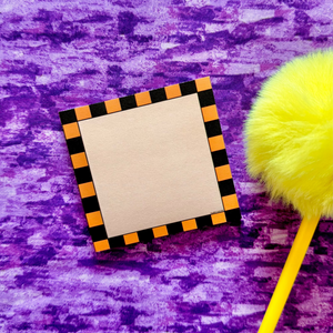 Square sticky notes with black and orange border and yellow pencil on purple textured background